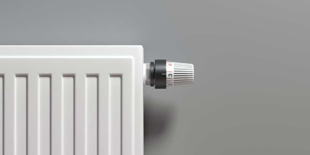 Radiator with thermostat, grey wall background. 3d illustration